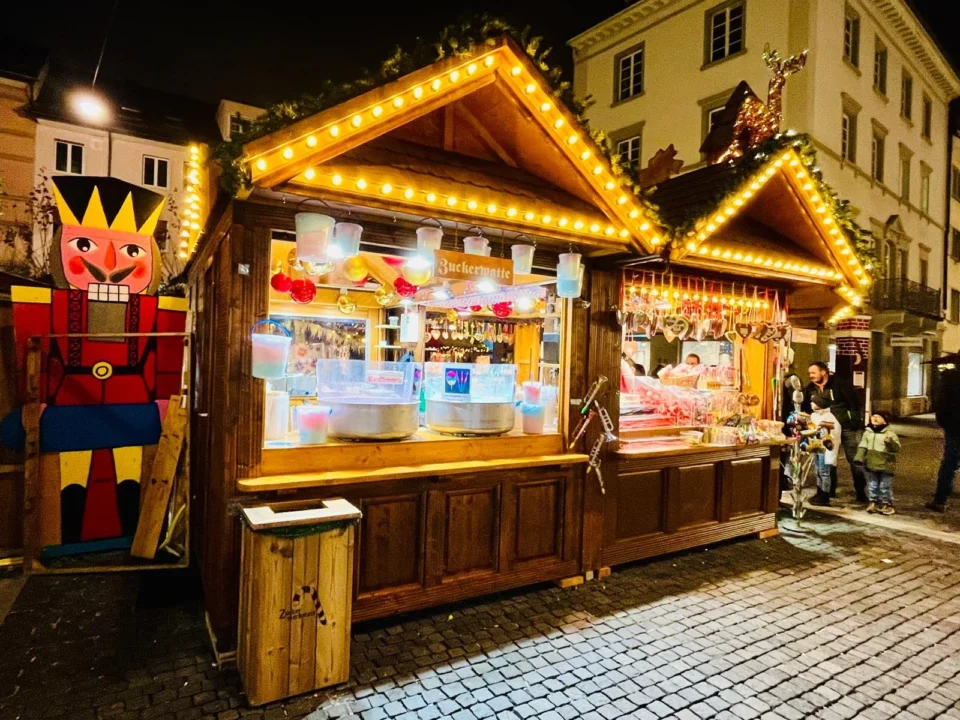 Zuckerwerkstatt Stand aus Holz mit Zuckerwatte, Lebkuchenherzen und weiteren Leckereien